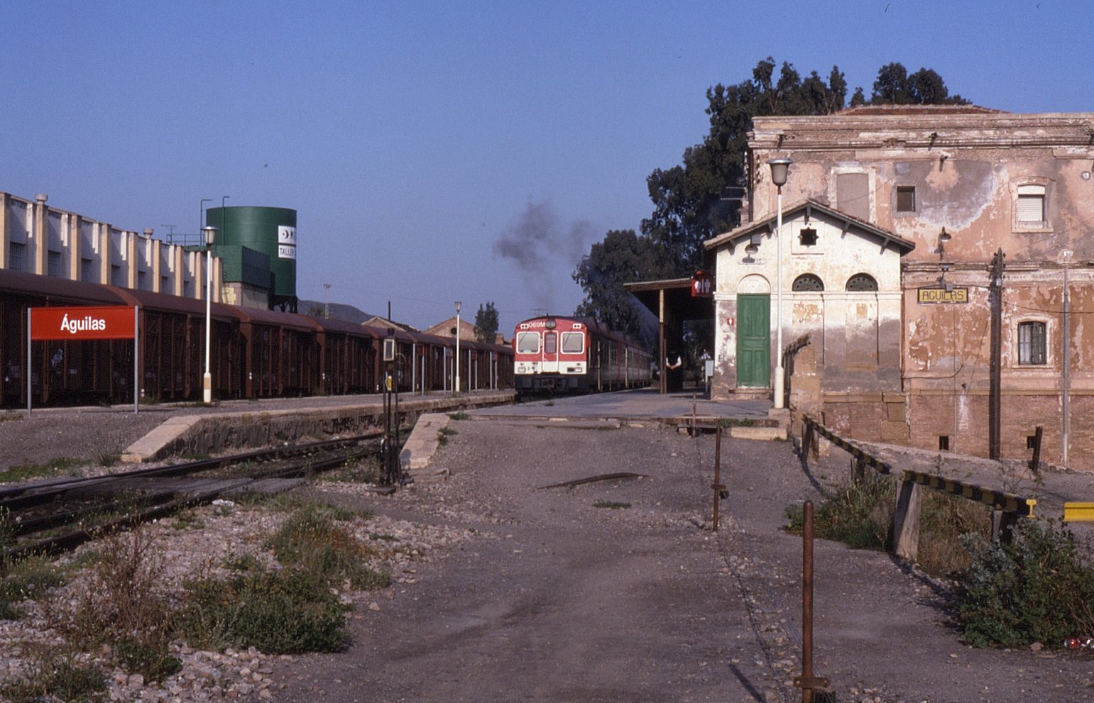 Andenes de la estación de Águilas con tren y rótulo