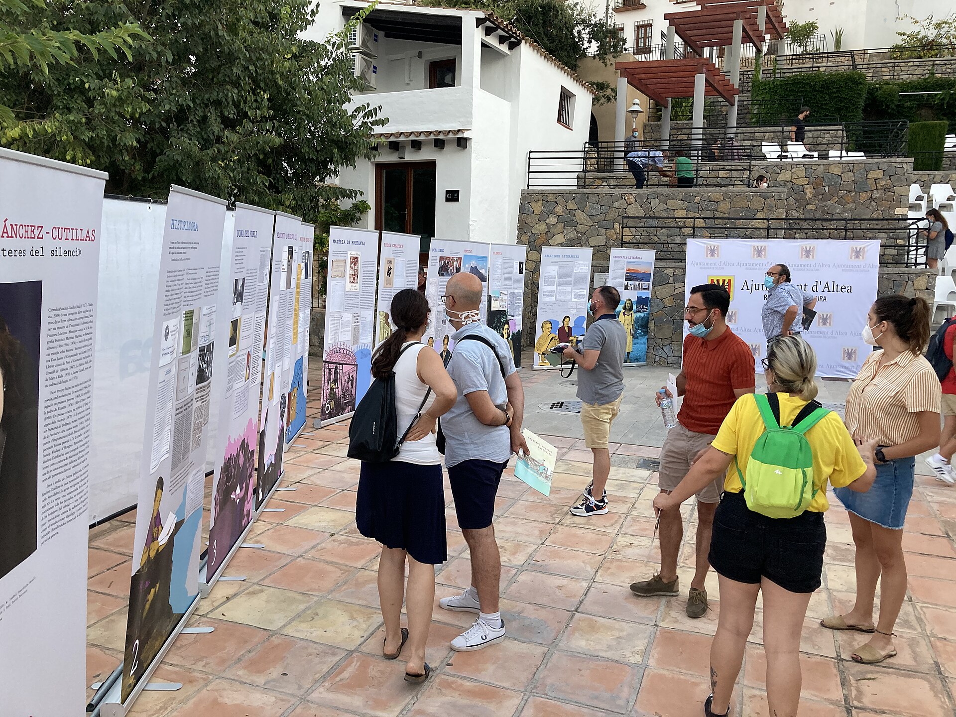 Exposició a l'aire lliure amb públic i façanes blanques d'Altea