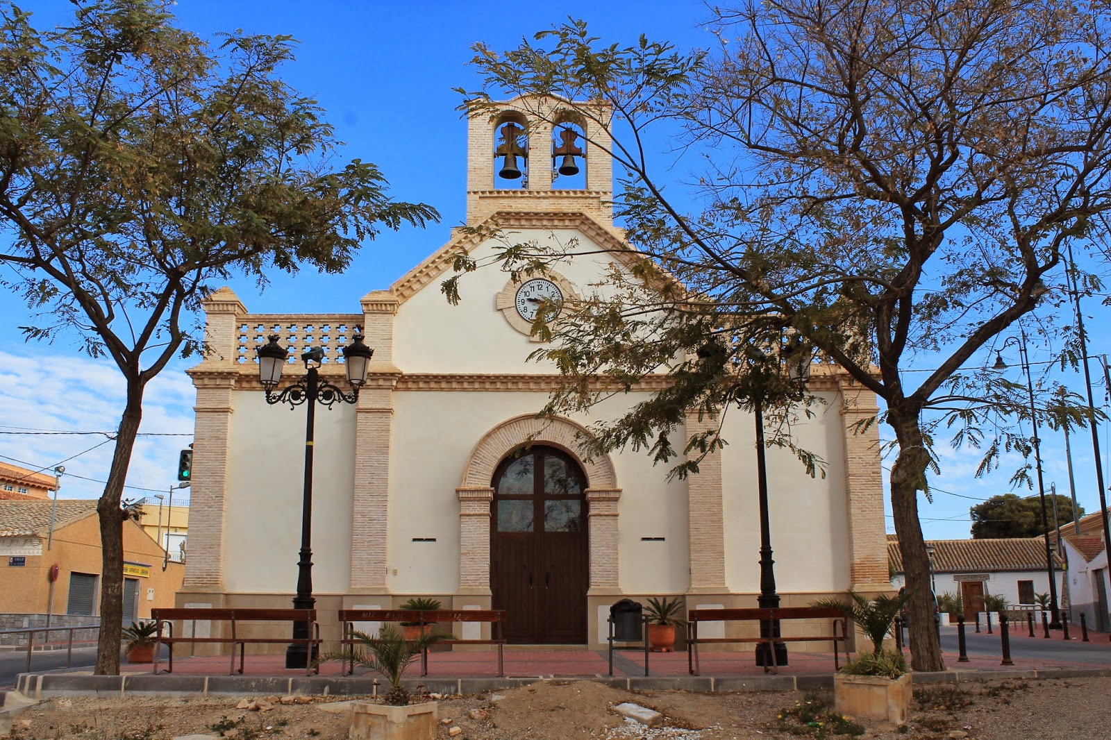 Fachada de la iglesia de Avileses con campanario y reloj