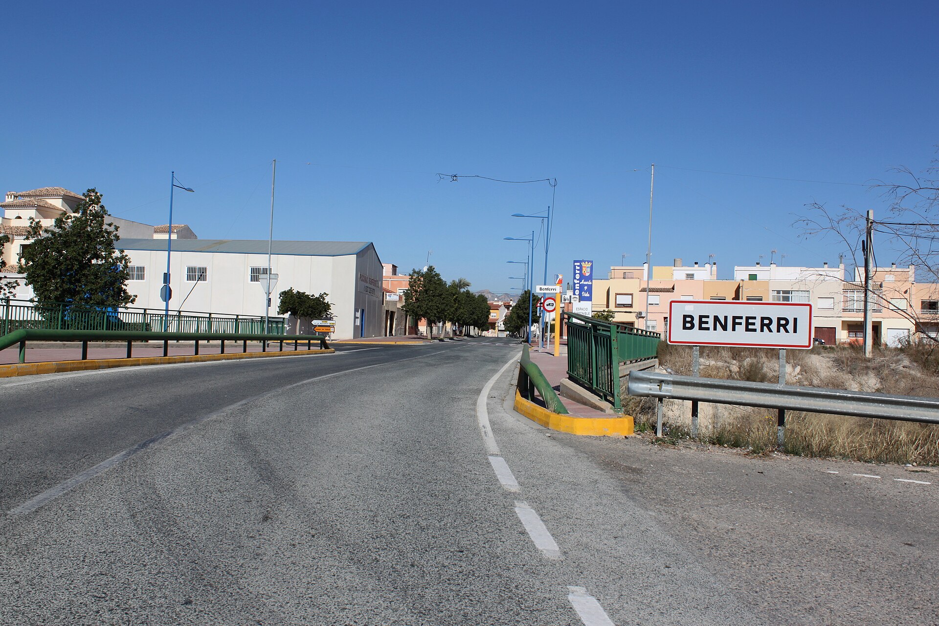 Entrada a Benferri con cartel de localidad y avenida