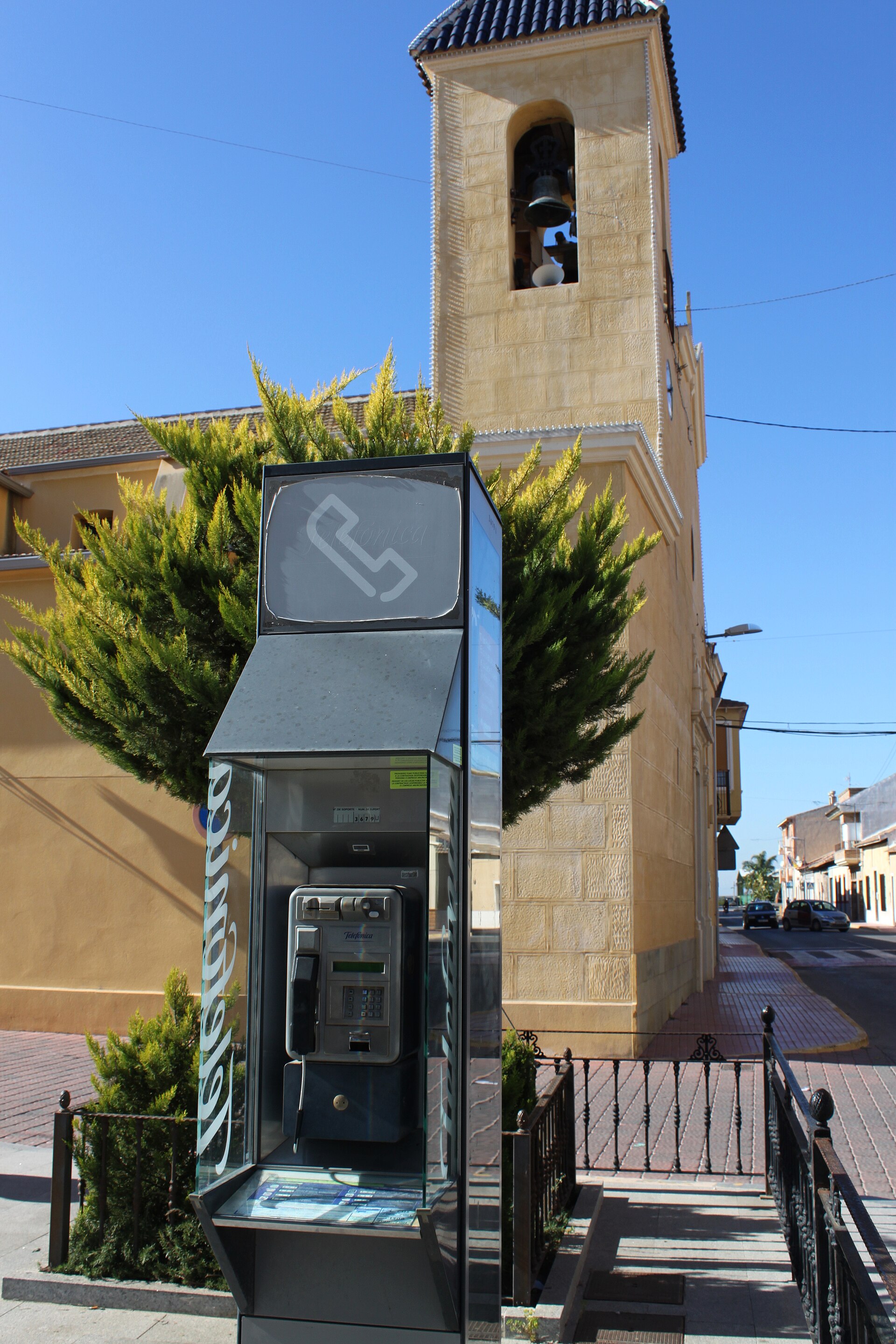 Daya Nueva — Cabina telefónica y campanario en primer plano