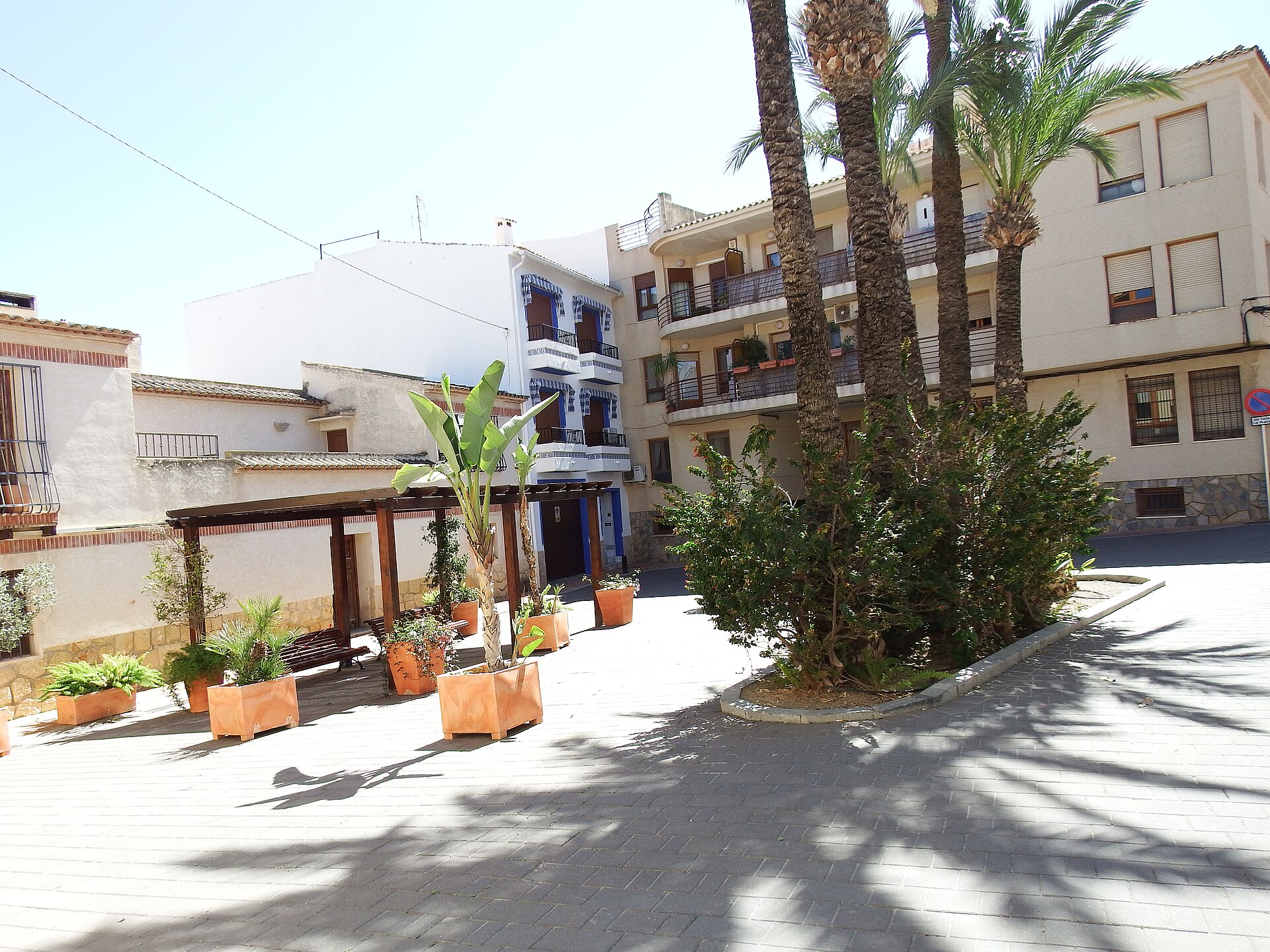 Plaza del núcleo histórico de La Nucia con palmeras y macetas