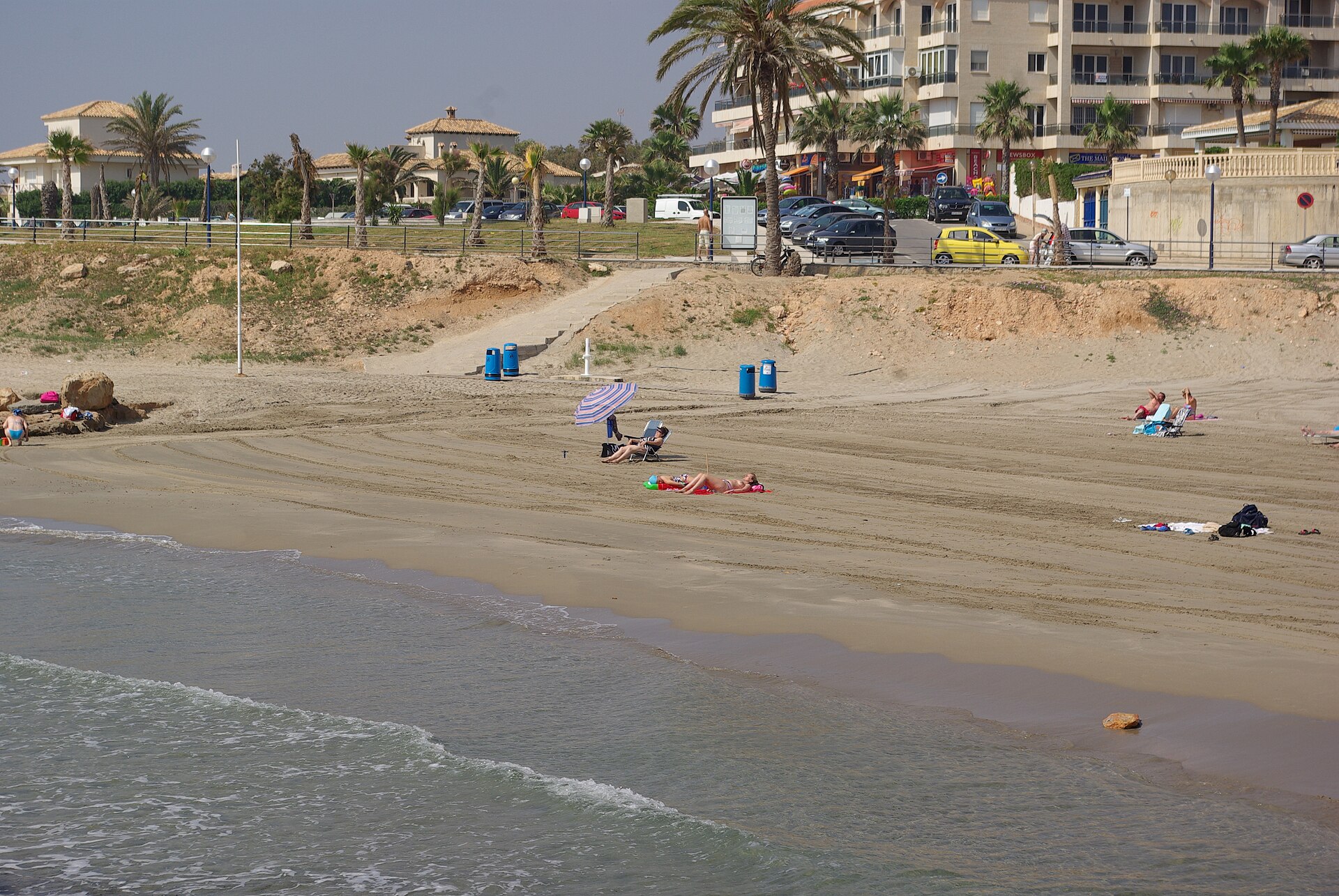 Playa Flamenca, arena y primer plano de la escollera y paseo