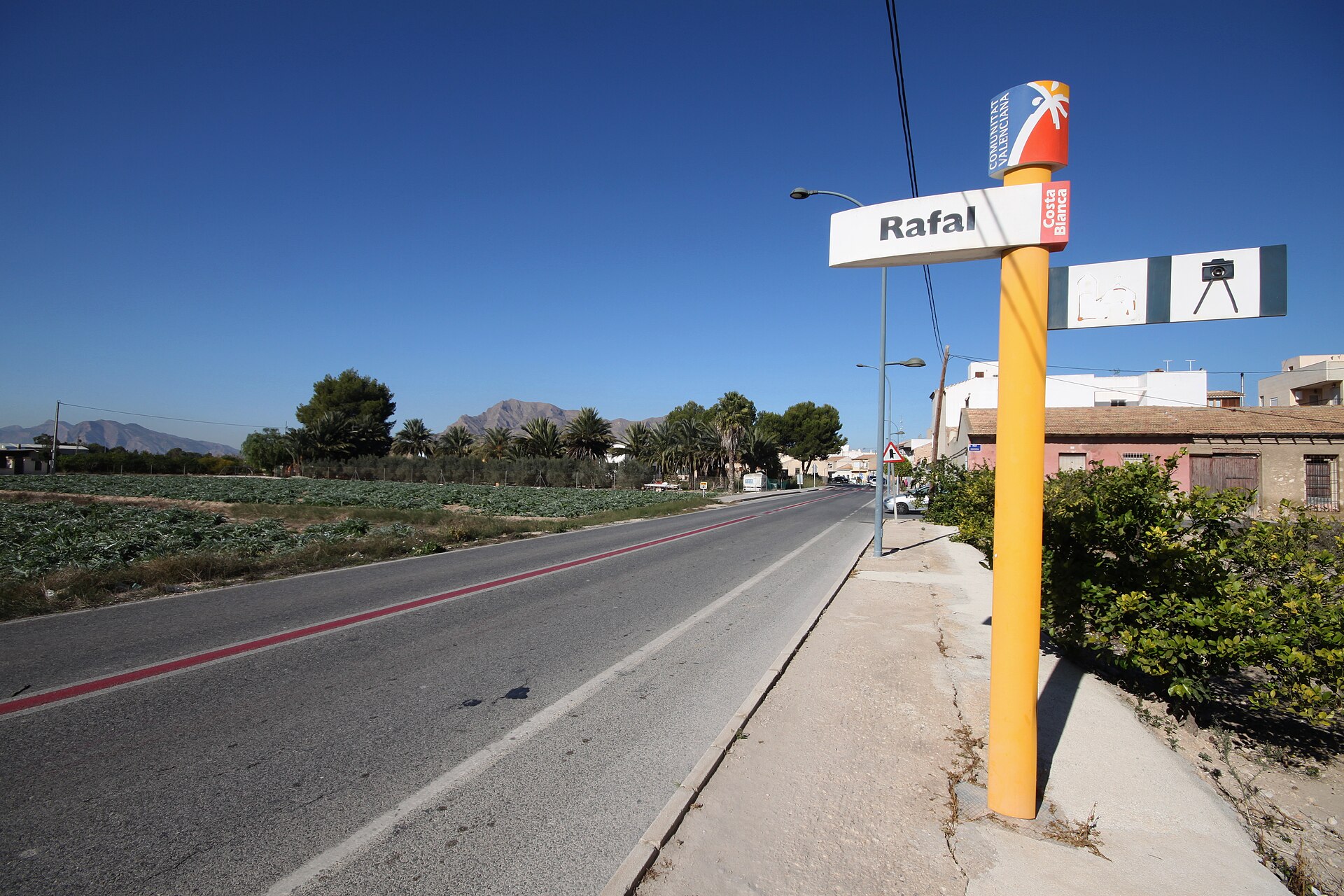 Cartel de entrada a Rafal junto a carretera y campos